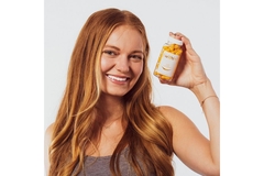 Image Woman holding bottle with Clear Within supplements containing turmeric extract